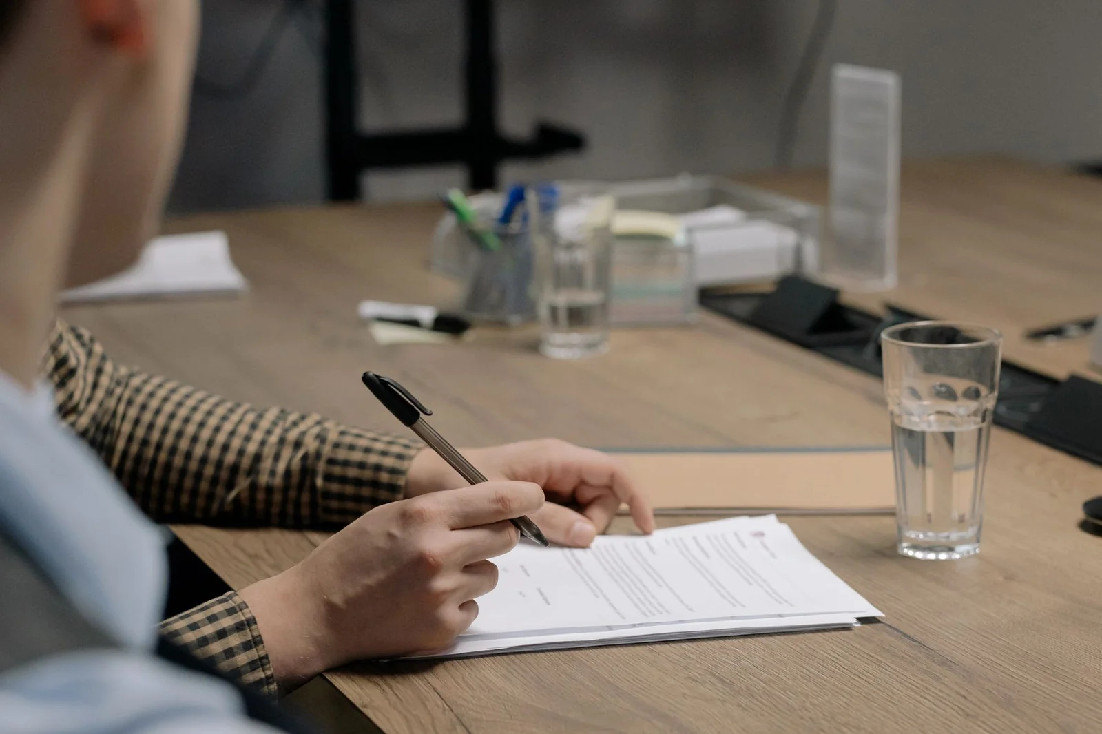 Mains annotant un contrat de location de box de stockage posé sur une table